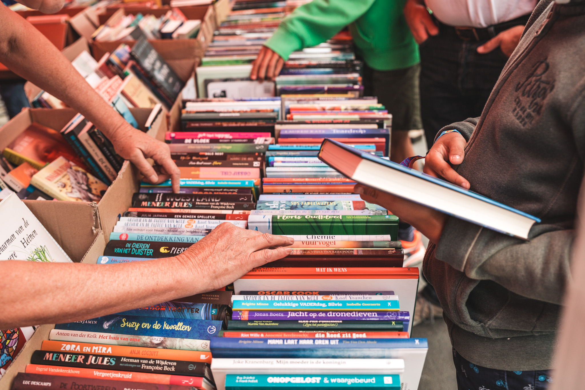 mensen snuisteren door boeken op een boekenmarkt