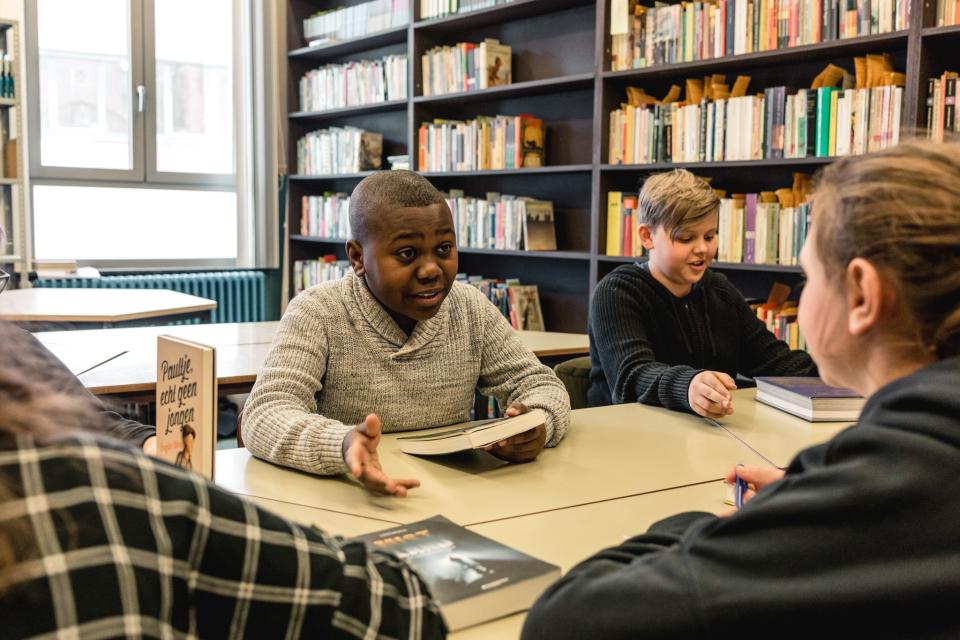 Leerlingen praten over boeken in een schoolbibliotheek